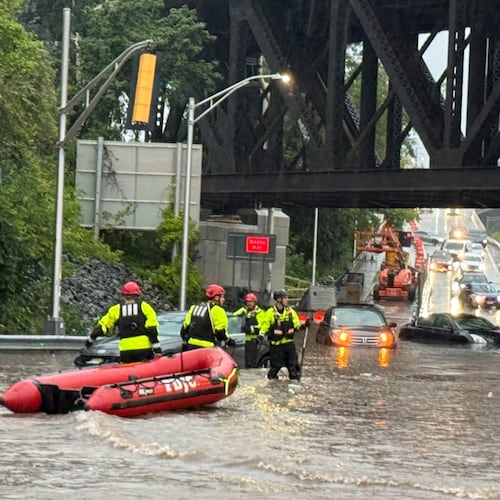 In this photo provided by the City of Jersey City, first responders try to rescue people stranded in a flooded street in Jersey City, N.J., Thursday, Aug. 20, 2026, after storms went through the area. (City of Jersey City via AP)