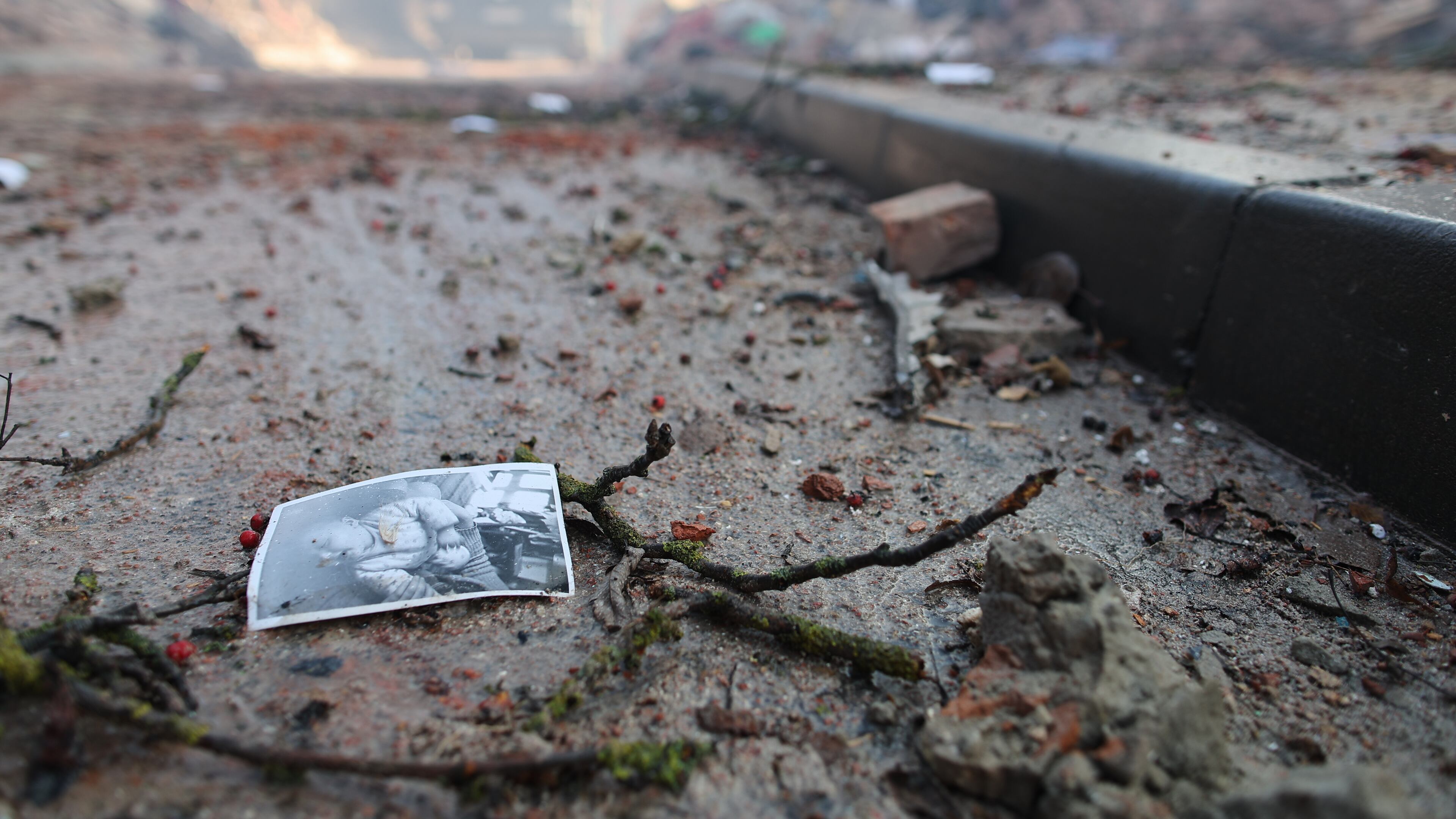 A photograph of a child lies on the ground near a residential building which was heavily damaged by a Russian strike on Ternopil, Ukraine, on Wednesday, Nov. 19, 2025. (AP Photo/Vlad Kravchuk)