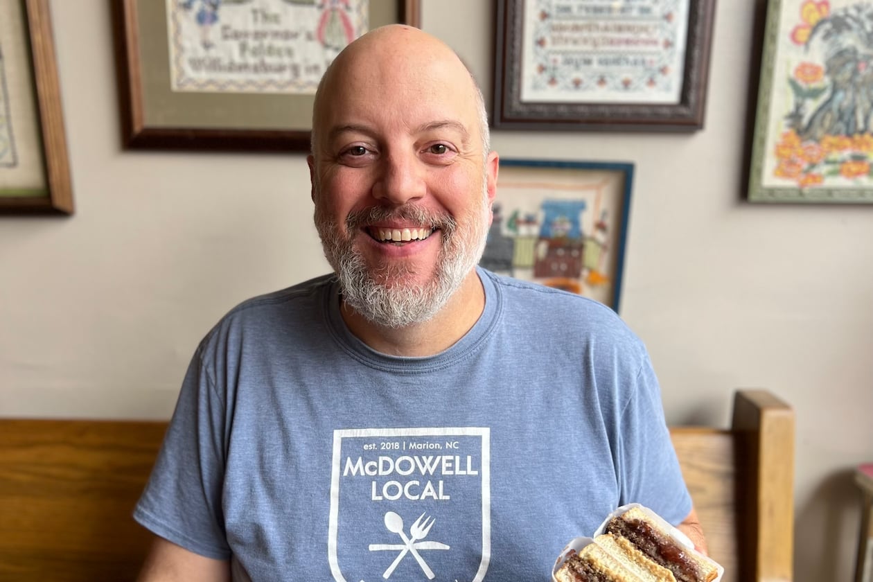 Aaron Mathews, owner and chef at McDowell Local, poses with his livermush sandwich. (Courtesy of Emma Mathews)