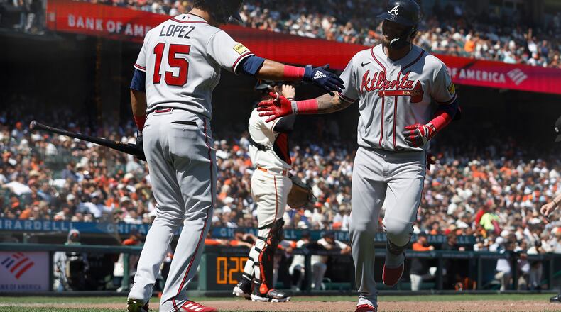 Orlando Arcia (11) of the Braves celebrates with Nicky Lopez (15) after hitting a solo home run in the top of the sixth inning against the San Francisco Giants at Oracle Park on Aug. 26, 2023, in San Francisco. (Lachlan Cunningham/Getty Images/TNS)