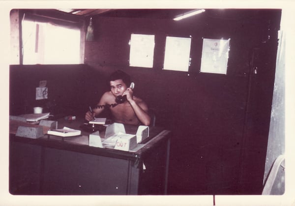 In this photo provided by William Fong, Fong is pictured in 1969 on the phone in an office known as orderly room in Landing Zone Baldy, a U.S. military base in Vietnam. (William Fong via AP)