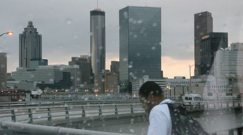 A few raindrops fall on Friday morning as a man walks near downtown Atlanta.