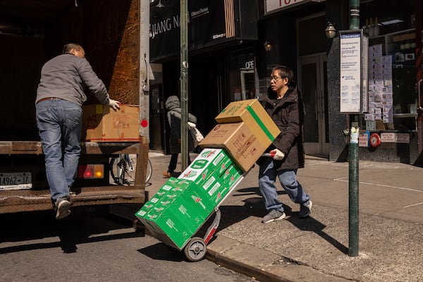 FILE - Delivery workers carry boxes outside a grocery store in the Chinatown neighborhood, Wednesday, April 9, 2025, in New York. (AP Photo/Yuki Iwamura, File)