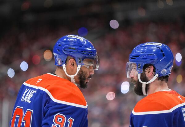 Edmonton Oilers' Evander Kane, left, talks to Adam Henrique before a faceoff during third period of Game 5 of the NHL Stanley Cup final against the Florida Panthers, in Edmonton, Alberta, Saturday, June 14, 2025. (Darryl Dyck/The Canadian Press via AP)