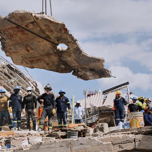 A crane lifts a concrete slab to clear the way for rescuers searching through the rubble three days after an earthquake hit Pereira, Colombia, Thursday, Aug. 13, 2026. (AP Photo/Brandon Pinto)