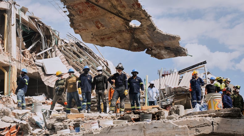 A crane lifts a concrete slab to clear the way for rescuers searching through the rubble three days after an earthquake hit Pereira, Colombia, Thursday, Aug. 13, 2026. (AP Photo/Brandon Pinto)