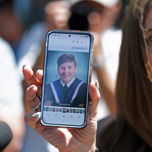 Kim Prosser holds a photo of her son Ashtyn outside the Ontario Court of Justice, Friday, May 29, 2026, in Newmarket, Ontario, after Kenneth Law pleaded guilty to 14 counts of counseling or aiding suicide, including the death of Prosser's son. (Christopher Drost/The Canadian Press via AP)