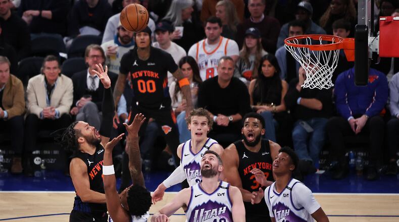 New York Knicks guard Jalen Brunson, left, shoots over Utah Jazz defenders during the second half of an NBA basketball game, Friday, Dec. 5, 2025, in New York. (AP Photo/Heather Khalifa)