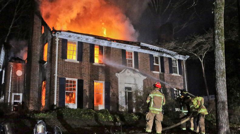 Atlanta firefighters work to contain the blaze in a historic Druid Hills mansion in this 2014 file photo. John Spink, jspink@ajc.com