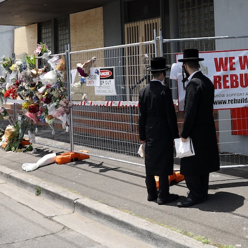 People gather outside the Adass Israel Synagogue, Dec. 9, 2024, after a firebombing in Melbourne, Australia. (Con Chronis/AAP Image via AP)