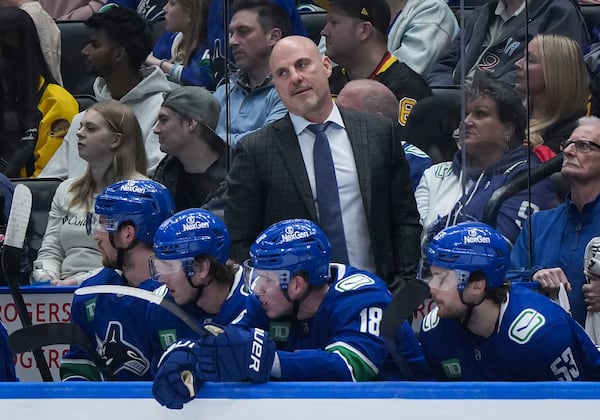 Vancouver Canucks head coach Rick Tocchet stands on the bench during the first period of an NHL hockey game against the Vegas Golden Knights in Vancouver, on Wednesday, April 16, 2025. (Darryl Dyck/The Canadian Press via AP)