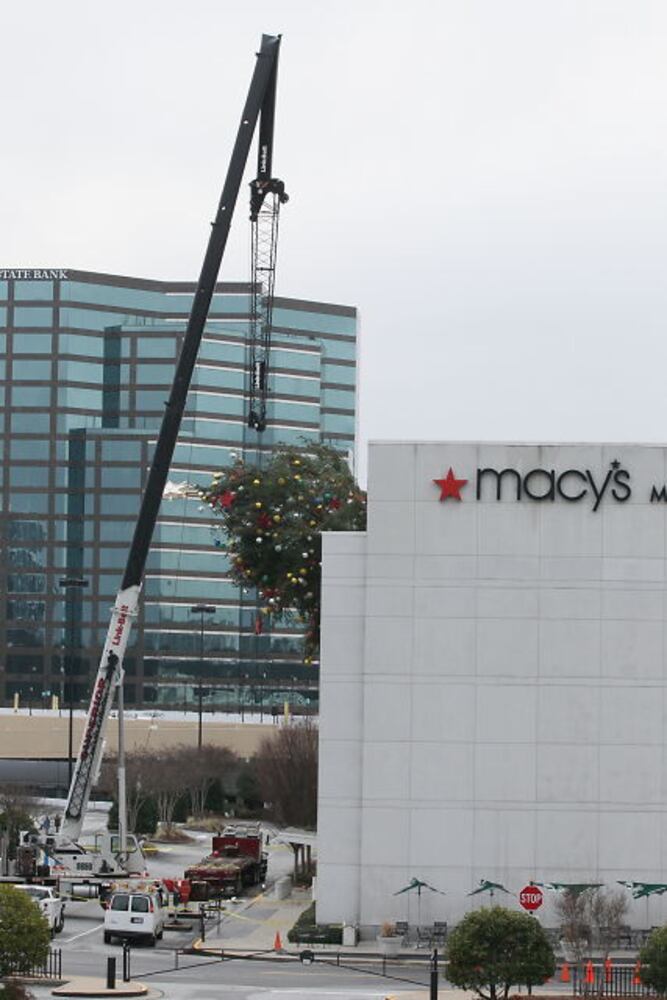 Crane buckles, leaving Christmas tree hanging off roof