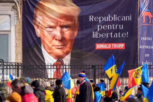 FILE - Supporters of Calin Georgescu, the winner of Romania's first round of presidential election, annulled by the Constitutional Court, march past a large banner showing U.S. President Donald Trump that reads "Republicans for Freedom" during a protest in Bucharest, Romania, Saturday, Feb. 22, 2025. (AP Photo/Andreea Alexandru, File)