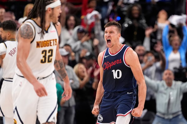 Los Angeles Clippers guard Bogdan Bogdanovic, right, reacts after scoring as Denver Nuggets forward Aaron Gordon looks on during the second half in Game 4 of an NBA basketball first-round playoff series Saturday, April 26, 2025, in Inglewood, Calif. (AP Photo/Mark J. Terrill)