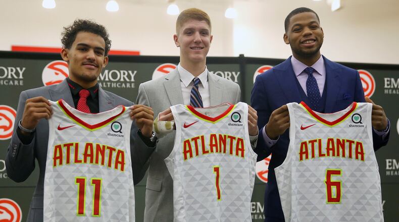 Atlanta Hawks NBA Draft first-round draft picks Trae Young (11), Kevin Huerter (1) and Omari Spellman (6) pose with their jerseys during a news conference Monday, June 25, 2018, in Atlanta.(AP photo/John Bazemore)
