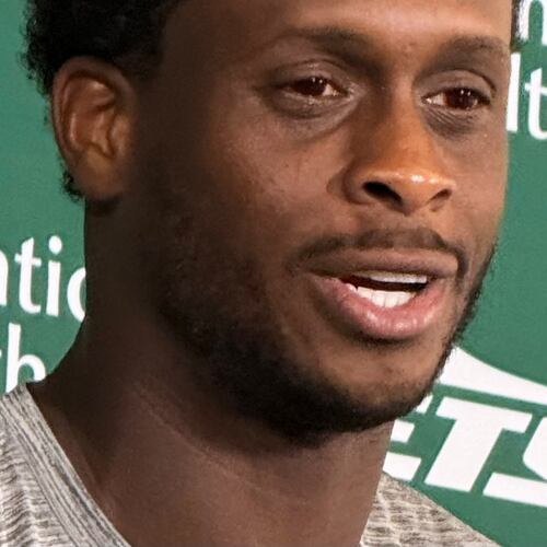 New York Jets quarterback Geno Smith, wearing red contact lenses, speaks to reporters after practice at the team’s training facility in Florham Park, N.J., on Thursday, Aug. 6, 2026. (AP Photo/Dennis Waszak Jr.)