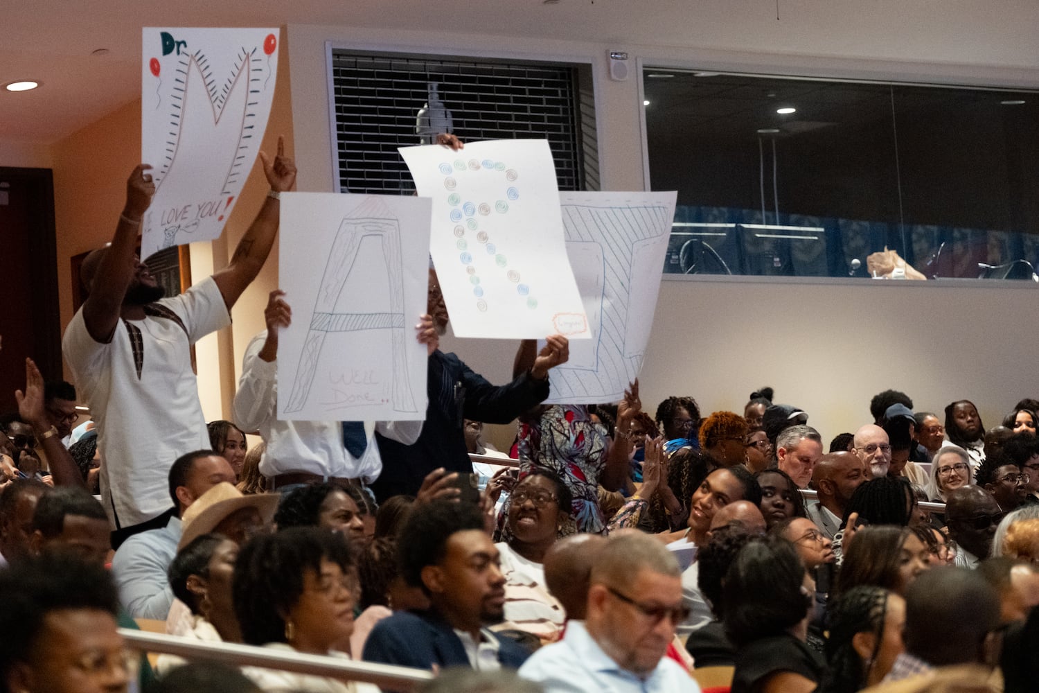 Family members hold up signs as Dr. Mari Chiles receives her degree during the Morehouse School of Medicine graduation ceremony on Saturday, May 16, 2026, in Atlanta. (Ben Gray for the AJC)