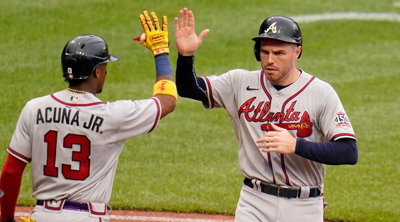 Atlanta Braves' Freddie Freeman, right, celebrates with Ronald Acuna Jr. after both scored on a double by Ehire Adrianza off Pittsburgh Pirates relief pitcher Duane Underwood Jr. during the eighth inning of a baseball game in Pittsburgh, Wednesday, July 7, 2021. (AP Photo/Gene J. Puskar)