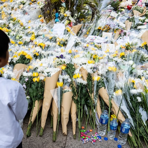 People offer flowers for the victims near the site of a deadly fire at Wang Fuk Court, a residential estate in the Tai Po district of Hong Kong's New Territories on Tuesday, Dec 2, 2025. (AP Photo/Chan Long Hei)