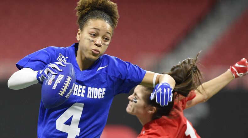 Peachtree Ridge quarterback Monique Thame, left, runs past a North Gwinnett player during the finals of the flag football championship Dec. 20, 2018 at Mercedes-Benz Stadium. The Gwinnett County girls flag football teams are playing exhibition games 4:30 to 6 p.m. Saturday at the Georgia World Congress Center as part of the pre-Super Bowl festivities. ANNIE RICE FOR THE AJC