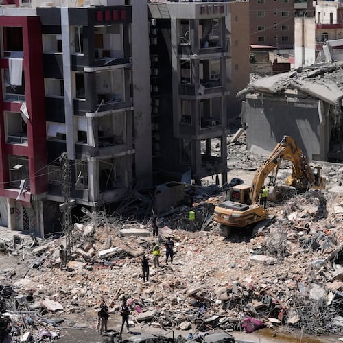 Rescue workers use an excavator, as they search for victims under the rubble of a building that was hit Monday in an Israeli airstrike in the southern port city of Tyre, Lebanon, Tuesday, June 2, 2026. (AP Photo/Mohammed Zaatari)