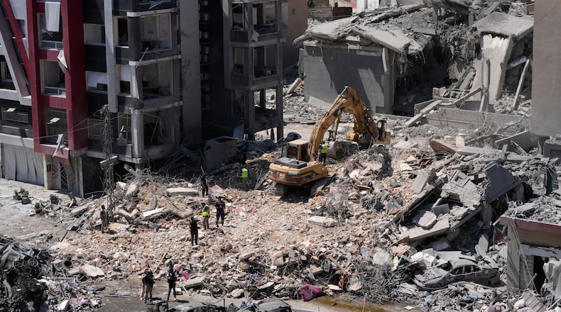Rescue workers use an excavator, as they search for victims under the rubble of a building that was hit Monday in an Israeli airstrike in the southern port city of Tyre, Lebanon, Tuesday, June 2, 2026. (AP Photo/Mohammed Zaatari)