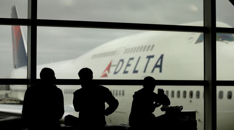 FILE - In this Monday, Oct. 29, 2012, file photo, travelers on Delta Airlines waits for flights, in Detroit. Delta said Superstorm Sandy hurt fourth-quarter profits by $100 million in 2012. That, plus special charges, left Delta Air Lines Inc. with a profit of just $7 million. (AP Photo/Charlie Riedel, file) AJC file
