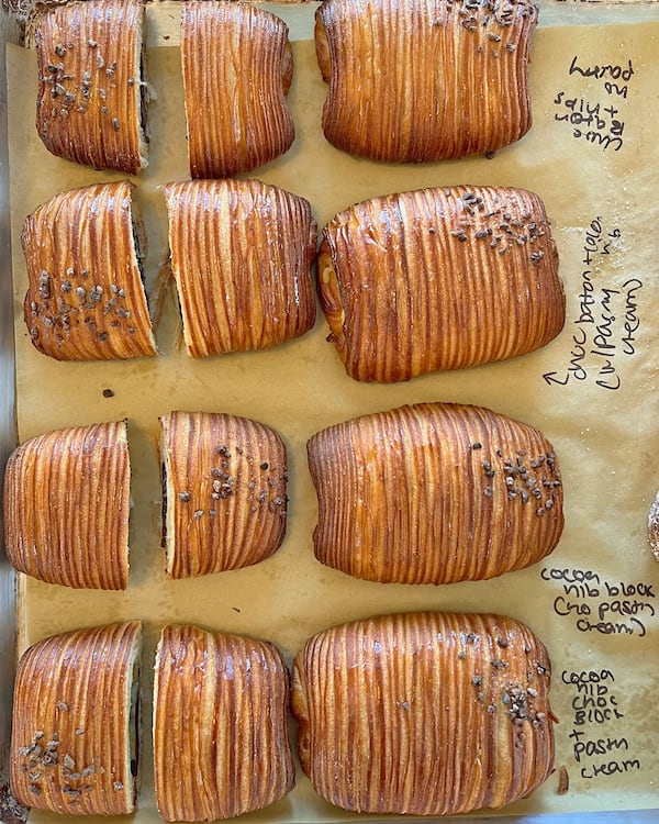 A sheet of parchment paper holds a row of eight flaky croissants from Summerland Cafe.