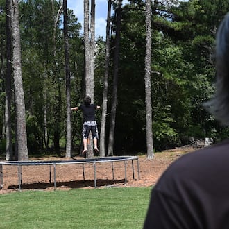 Gabe Richard watches his son play in their backyard. Richard and his wife, Nichole, say their son, who has autism, was harmed by a state program designed to help students with emotional and behavioral disabilities. (Hyosub Shin/AJC)