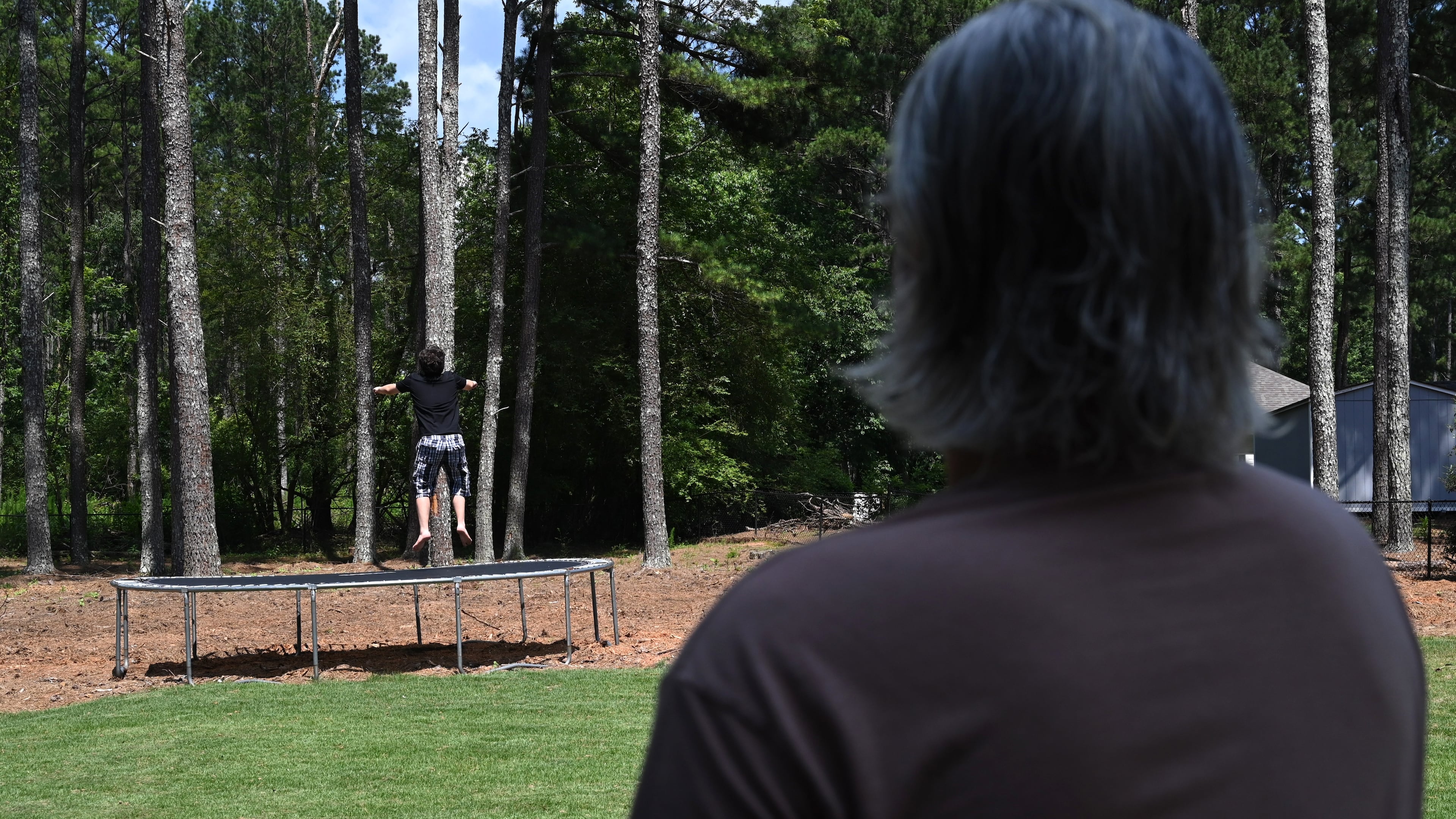 Gabe Richard watches his son play in their backyard. Richard and his wife, Nichole, say their son, who has autism, was harmed by a state program designed to help students with emotional and behavioral disabilities. (Hyosub Shin/AJC)