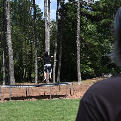 Gabe Richard watches his son play in their backyard. Richard and his wife, Nichole, say their son, who has autism, was harmed by a state program designed to help students with emotional and behavioral disabilities. (Hyosub Shin/AJC)