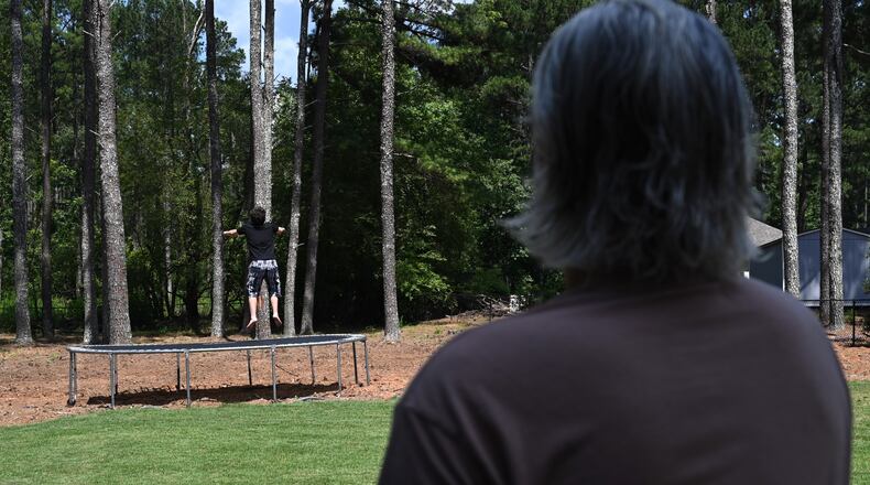 Gabe Richard watches his son play in their backyard. Richard and his wife, Nichole, say their son, who has autism, was harmed by a state program designed to help students with emotional and behavioral disabilities. (Hyosub Shin/AJC)