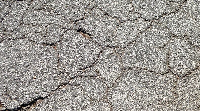 This is what it looks like when a street needs milling, repairing and paving. This is Swanton Way in Decatur several years ago, shortly before it was fixed. Later this summer the city will renovate three more residential streets. Bill Banks file photo for the AJC