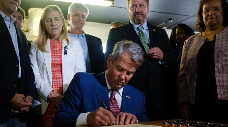 Gov. Brian Kemp signs a $1 billion tax cut bill in Bonaire in 2022. Georgia has been cutting income tax rates for years, and some elected officials want to eliminate the tax altogether. (Arvin Temkar/AJC/TNS)
