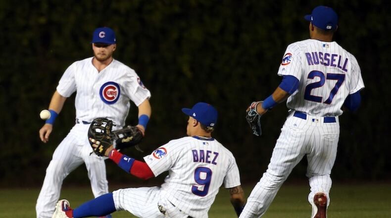 Chicago Cubs center fielder Ian Happ, second baseman Javier Baez (9), and shortstop Addison Russell (27) surround a double by the Cincinnati Reds' Jose Peraza during the fourth inning at Wrigley Field in Chicago on Tuesday, May 16, 2017. (Nuccio DiNuzzo/Chicago Tribune/TNS)