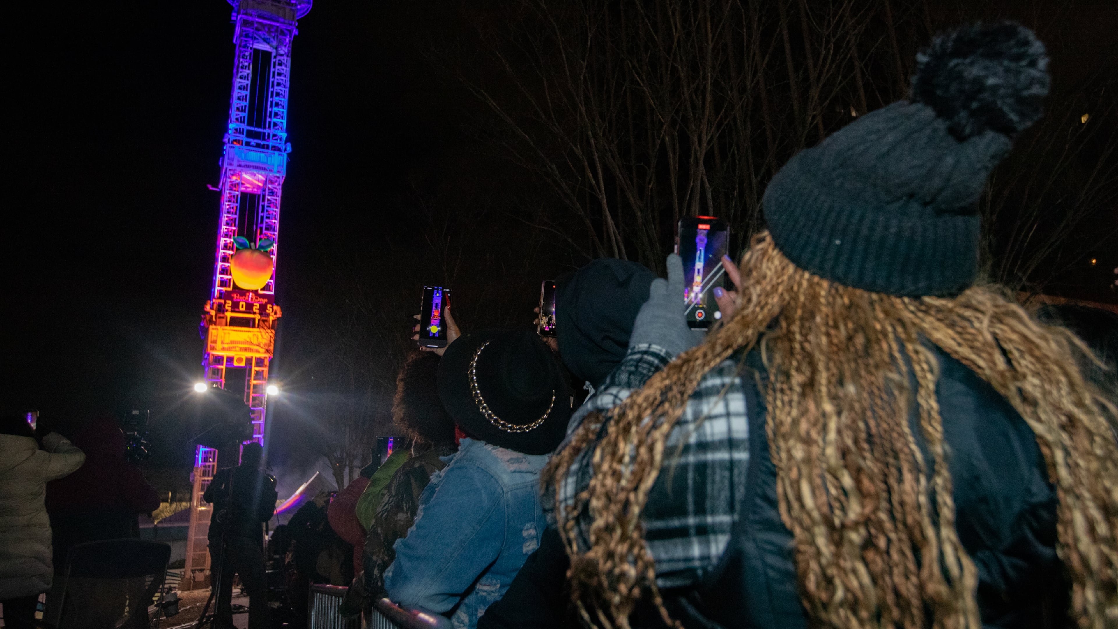 Kywanda Hammothe, right, captures the drop during the countdown to 2025. (Jenni Girtman for The Atlanta Journal-Constitution)
