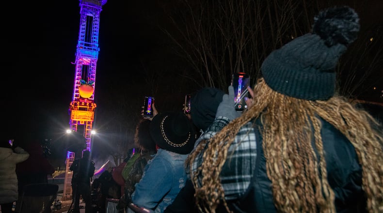 Kywanda Hammothe (right) captures the Peach Drop during the countdown to 2025. The new year is a great time for a fresh start. (Jenni Girtman for the AJC)