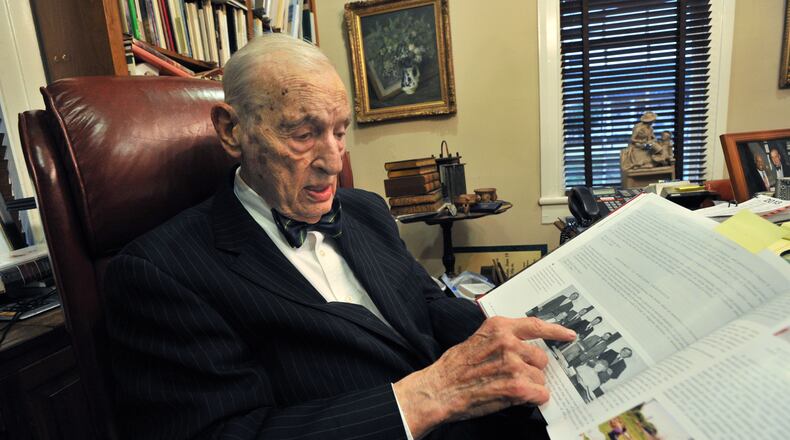 Fred “Bowtie” Bentley Sr.,points out an entry in the book "Historic Kennesaw - 1887-2012 Celebrating 125 Years," at his office in Marietta in 2012. The longtime lawyer and Kennesaw native died Thursday, Oct. 3, 2019, at age 92. (AJC file photo)