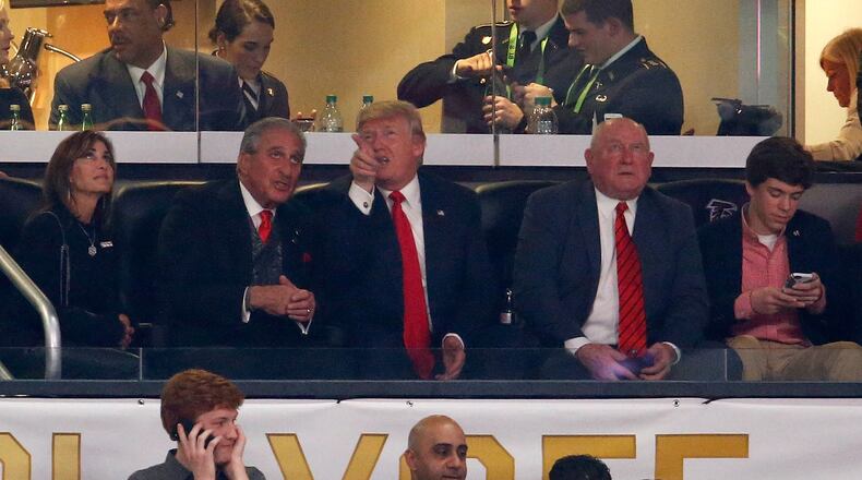 U.S. President Donald Trump talks to Arthur Blank, owner of the Atlanta Falcons, and his wife Angie, during the game between the Georgia Bulldogs and Alabama Crimson Tide in the CFP National Championship presented by AT&T at Mercedes-Benz Stadium on January 8, 2018 in Atlanta.