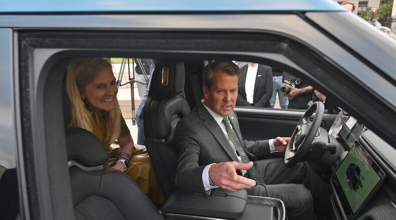 December 16, 2021 Atlanta - Georgia Governor Brian Kemp and First Lady Marty Kemp react as they sit inside Rivian R1T electric truck during a press conference at Liberty Plaza across from the Georgia State Capitol in Atlanta on Thursday, December 16, 2021. Electric vehicle maker Rivian on Thursday confirmed its plans to build a $5 billion assembly plant and battery factory in Georgia, which Gov. Brian Kemp called the largest single economic development project ever in this state's history. (Hyosub Shin / Hyosub.Shin@ajc.com)