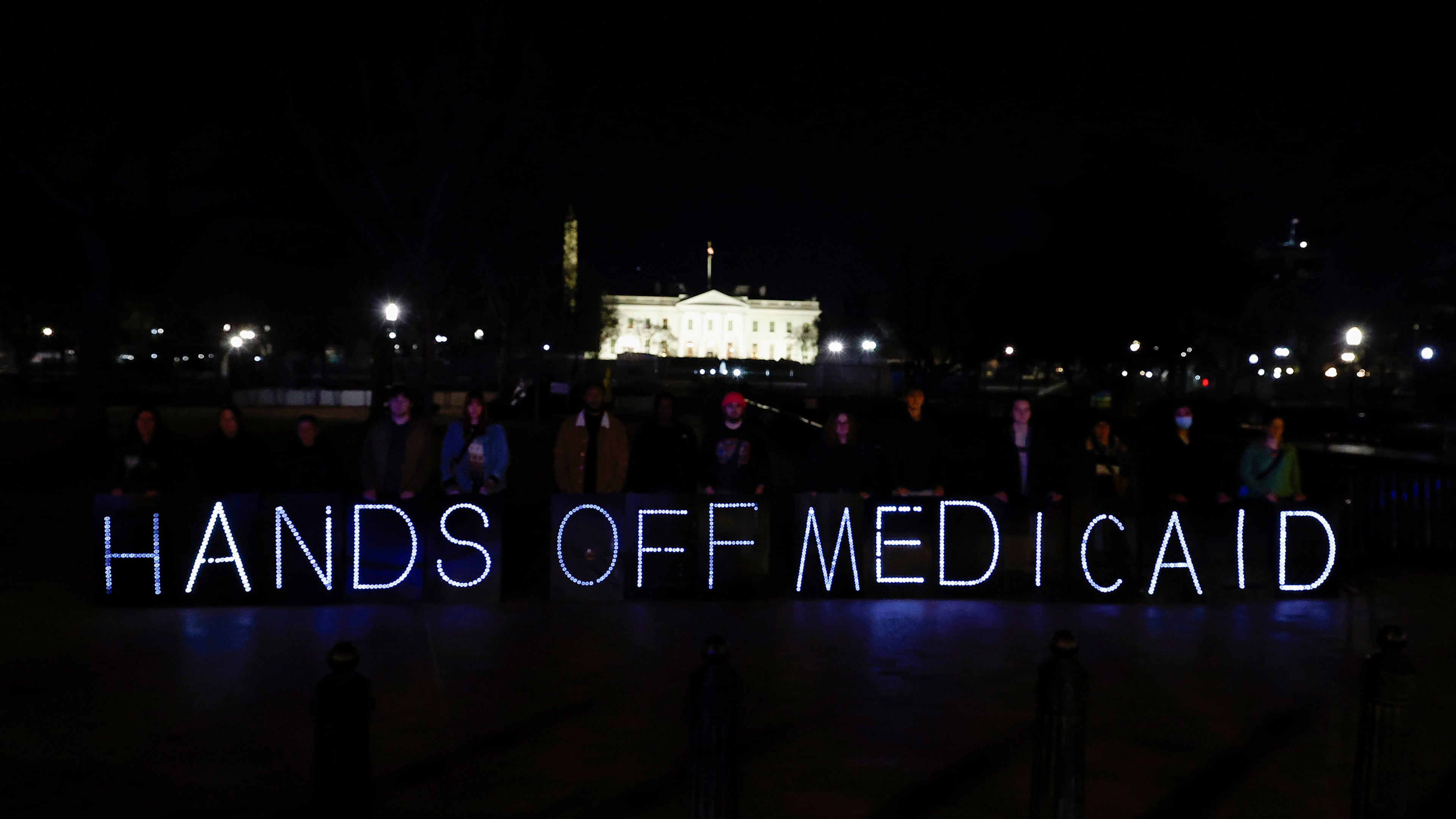 Protesters display a "Hands Off Medicaid" message in March in front of the White House in opposition of the Republican budget plan, which when passed slashed Medicaid by nearly $1 trillion. (Paul Morigi/TNS 2025)