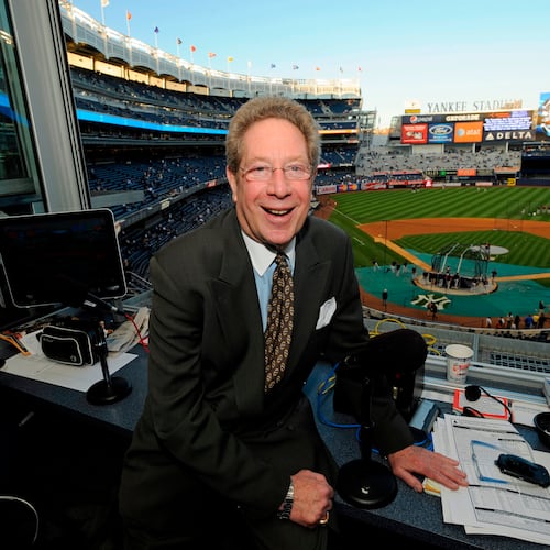 FILE - In this Sept. 25, 2009 file photo shows New York Yankees broadcaster John Sterling sitting in his booth before a baseball game against the Boston Red Sox at Yankee Stadium in New York. (AP Photo/Bill Kostroun, file)