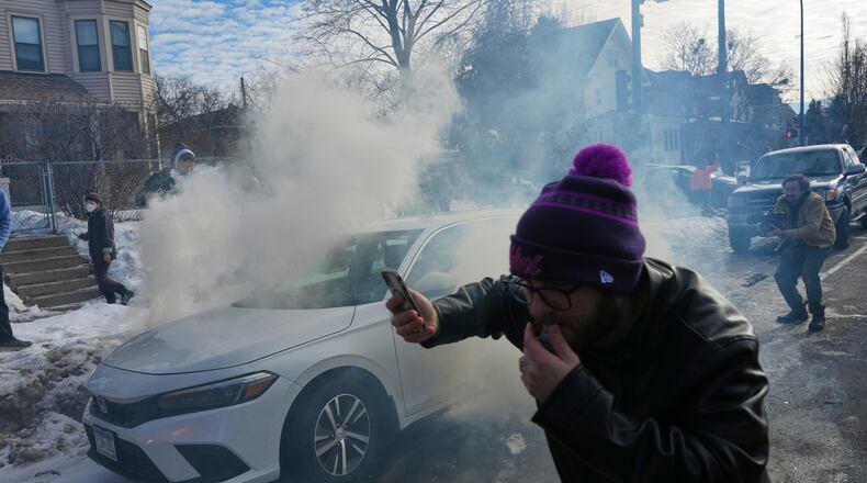 Protesters try to avoid tear gas dispersed by federal agents, Monday, Jan. 12, 2026 in Minneapolis (AP Photo/Adam Gray)
