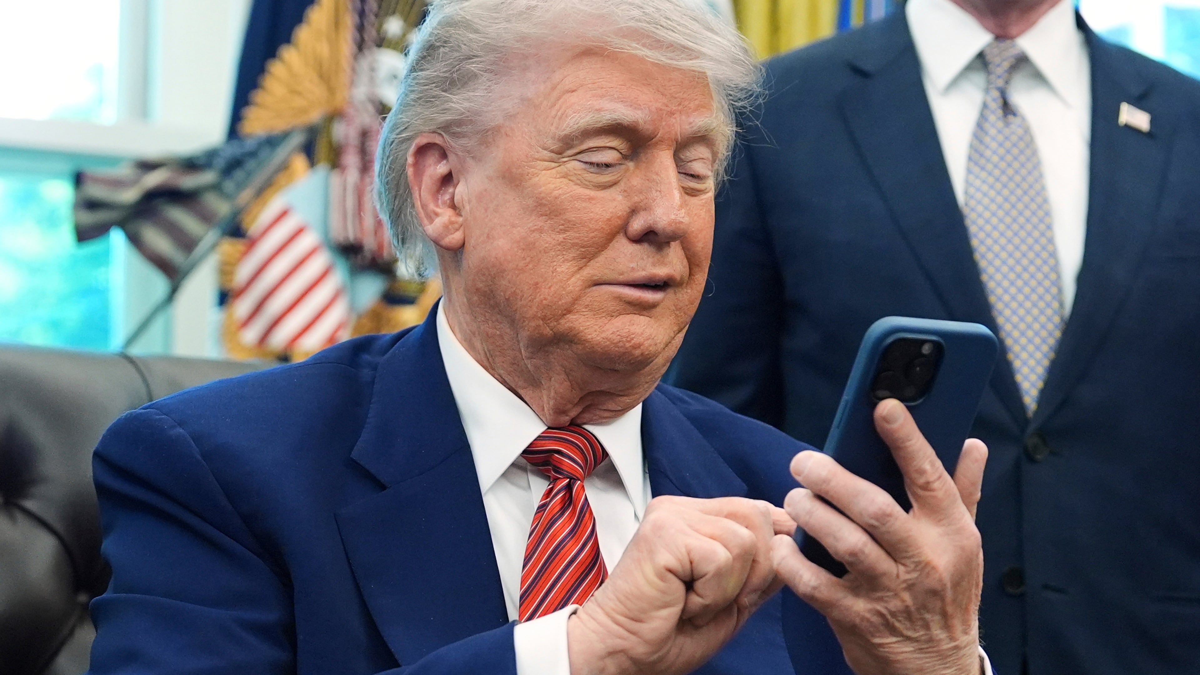 FILE - President Donald Trump silences his mobile phone in the Oval Office of the White House, May 23, 2025, in Washington. (AP Photo/Evan Vucci, File)