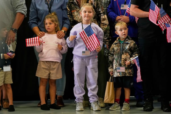 Young Afrikaner refugees from South Africa holding American flags arrive, Monday, May 12, 2025, at Dulles International Airport in Dulles, Va. (AP Photo/Julia Demaree Nikhinson)