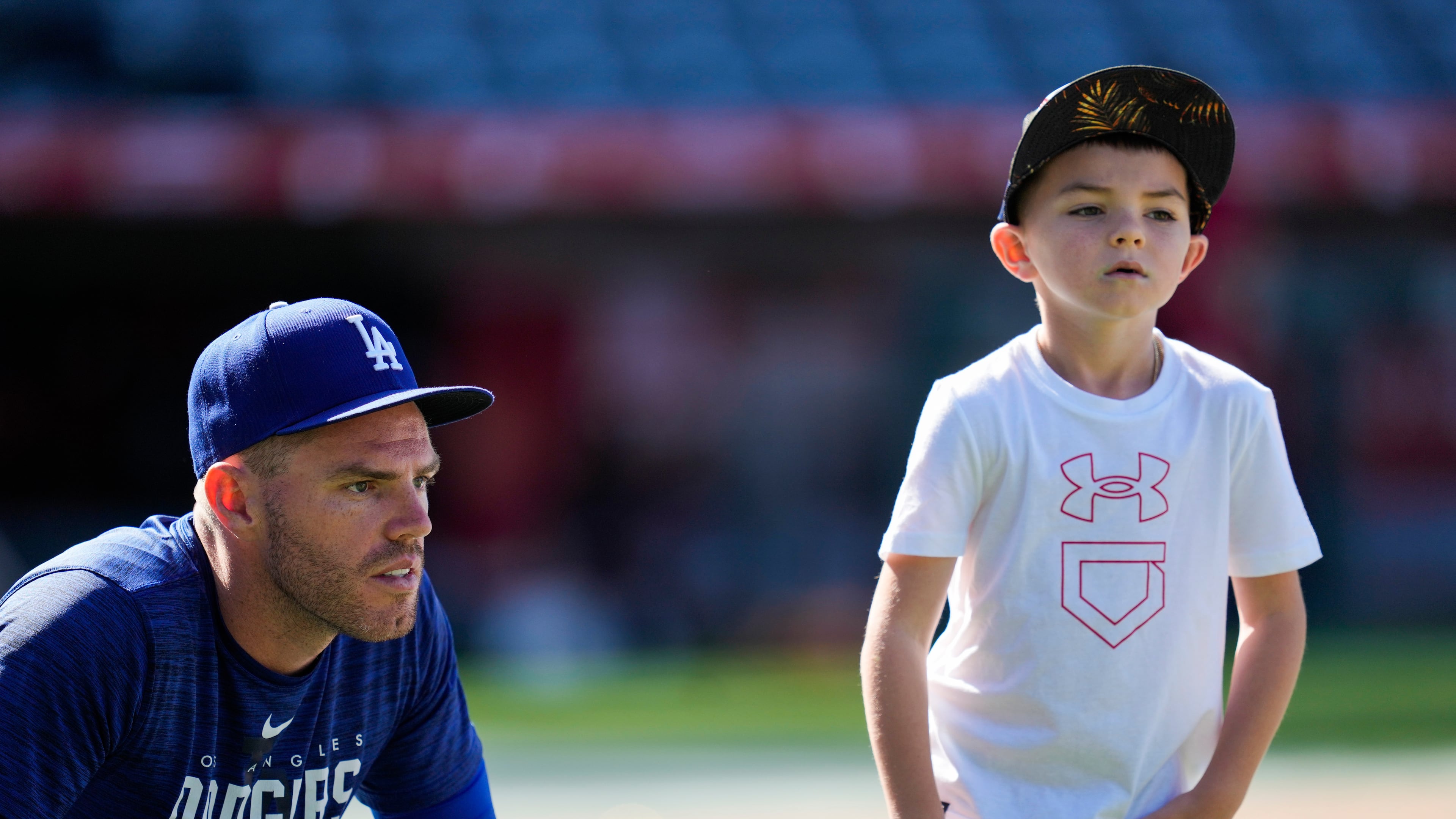 FILE - Los Angeles Dodgers first baseman Freddie Freeman (5) and his son, Charlie Freeman, participate in batting practice before a baseball game against the Los Angeles Angels in Anaheim, Calif., June 21, 2023. (AP Photo/Ashley Landis, File)