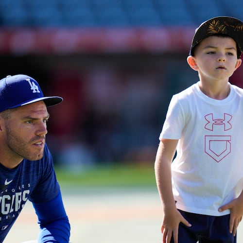 FILE - Los Angeles Dodgers first baseman Freddie Freeman (5) and his son, Charlie Freeman, participate in batting practice before a baseball game against the Los Angeles Angels in Anaheim, Calif., June 21, 2023. (AP Photo/Ashley Landis, File)