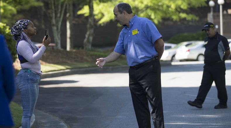 Waffle House Vice President of risk management John Fervier, center, asks Nicole Borden, left, to walk off the Waffle House corporate campus headquarters during a protest in Norcross, Monday, April 30, 2018. ALYSSA POINTER/ALYSSA.POINTER@AJC.COM