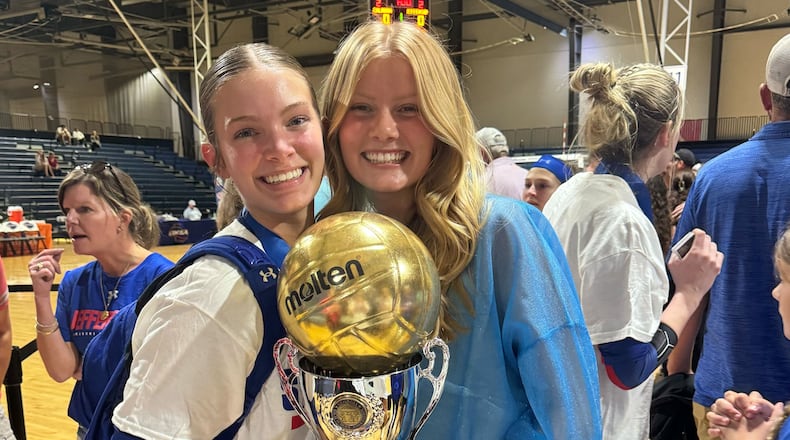 Sisters Hannah, left, and Abbey Howard, right, pose with Jefferson's first state trophy for volleyball after the championship game in November. Photo credit/Christi Howard.