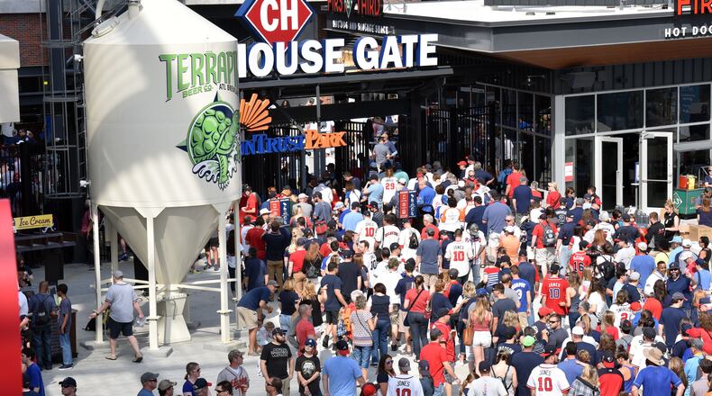April 14, 2017 ATLANTA Fans enter the stadium through the Chophouse Gate to see the Atlanta Braves play the San Diego Padres in the season opener in the new SunTrust Park Friday, April 14, 2017. HYOSUB SHIN / AJC